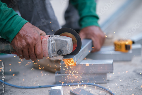 Using a Abrasive Cutoff Machine or chop saw on the floor to cut a piece of steel square tube.