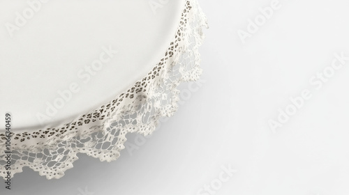 A delicate white lace trim adorns the edge of a round plate, creating an elegant and vintage aesthetic. photo