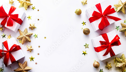 Christmas background featuring white gift boxes tied with vibrant red ribbons, placed along the sides to create a visually appealing border. The gifts are surrounded by golden stars, baubles