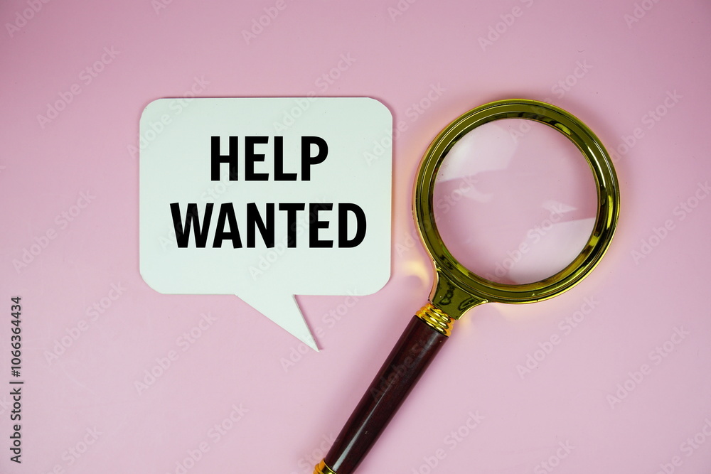 Help Wanted text on speech bubble with magnifying glass top view on pink background Help Wanted text on speech bubble with magnifying glass top view on pink background