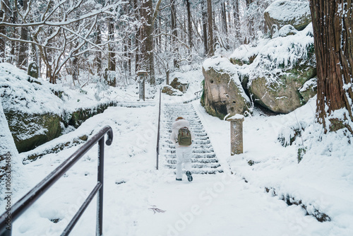 Woman tourist sightseeing Yamadera temple with snow in winter, traveler travel Risshakuji temple in Yamagata City, in Yamagata Prefecture, Tohuku, Japan. Landmark for tourists attraction in Japan photo