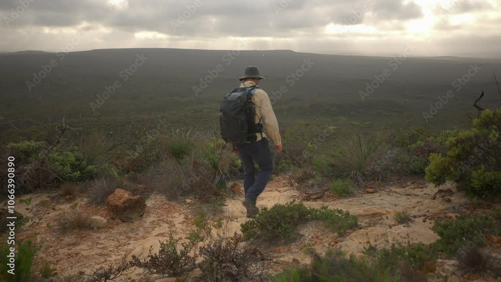 Person hiking downhill with a stunning background in the south west of Western Australia. Person hiking downhill with a stunning background in the south west of Western Australia.