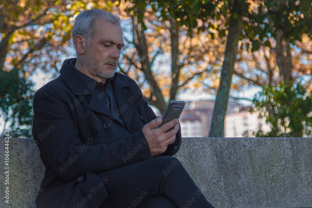 Middle-aged man texting on bench Middle-aged man texting on bench