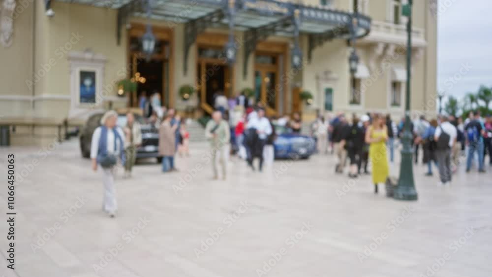 Crowd gathers in front of a luxurious monaco building, with men and women blurred in a lively outdoor setting. Crowd gathers in front of a luxurious monaco building, with men and women blurred in a lively outdoor setting.