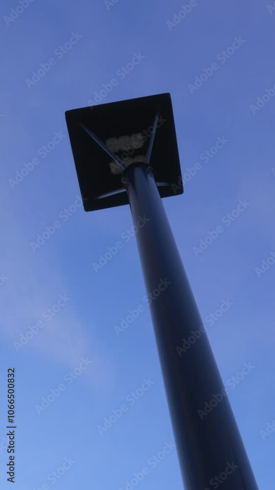 A modern street lamp on a blue sky background. Vertical video. A modern street lamp on a blue sky background. Vertical video.