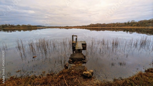 Obraz na płótnie Cloudy lakeside landscape scenery, fishing dock, jetty at Ballyqiurke lough, Moycullen, Galway, Ireland, nature background w salonie