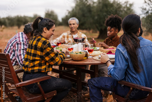 Farmers enjoying lunch together in olive grove after harvesting olives