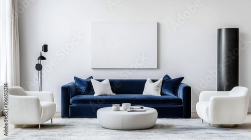 Modern living room with a blue velvet sofa, white armchairs, and a round ottoman.