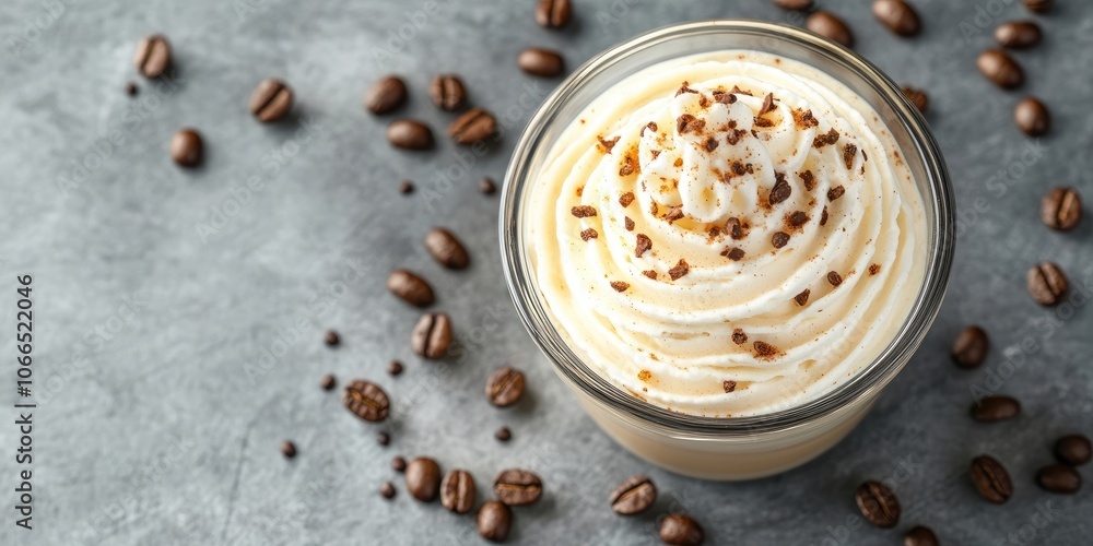 A cup of fragrant coffee adorned with creamy whipped topping and garnished with coffee beans can be seen from above, showcasing its delightful presentation. A cup of fragrant coffee adorned with creamy whipped topping and garnished with coffee beans can be seen from above, showcasing its delightful presentation.