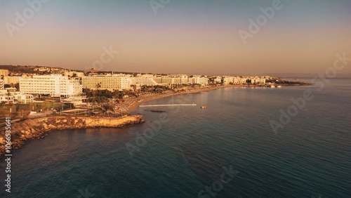 Coastal cityscape with hotels at sunset.