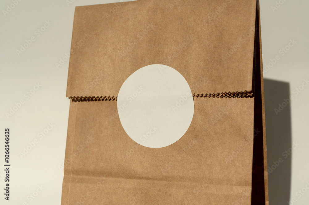 Brown paper bag with white round sticker on fold
