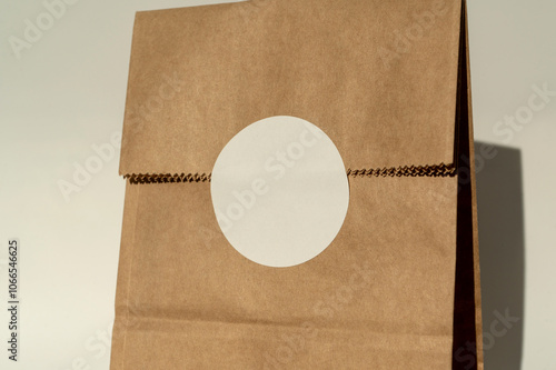 Obraz na płótnie Brown paper bag with white round sticker on fold w salonie