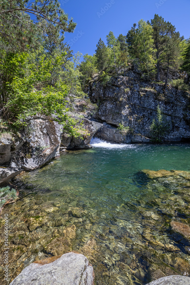 Scenic view of waterfall and lake in a Spanish Pyrenees Mountain in a sunny day. Transparent clear water. Scenic view of waterfall and lake in a Spanish Pyrenees Mountain in a sunny day. Transparent clear water.