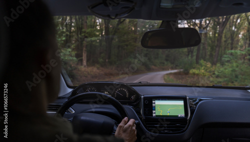Obraz na płótnie Woman driving a car on a forest road, shot from behind w salonie