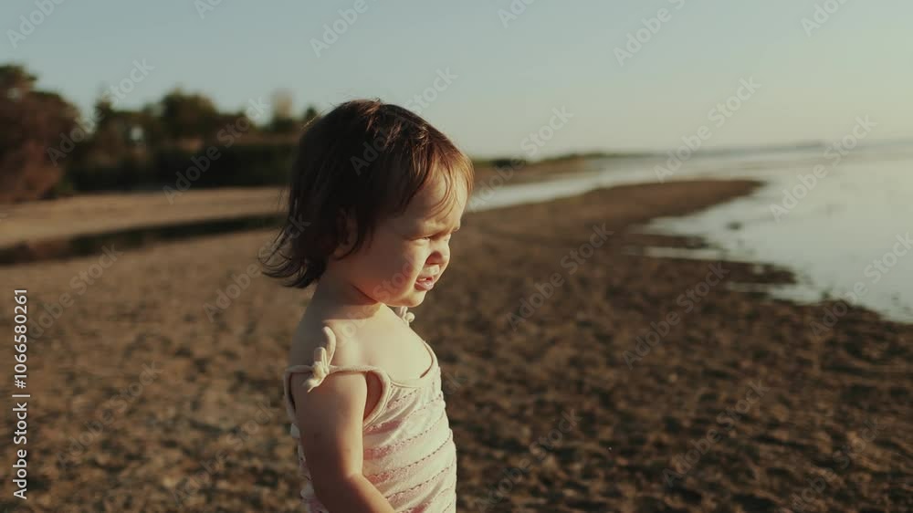 A Joyful and Cheerful Toddler Happily Exploring the Beach During a Beautiful Sunset Moment A Joyful and Cheerful Toddler Happily Exploring the Beach During a Beautiful Sunset Moment