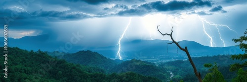 Lightning strikes over a mountainous landscape, illuminating the dark clouds above photo