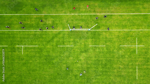 Aerial view of a rugby match on a green field. A vibrant aerial view of a rugby game in progress on a bright green field.