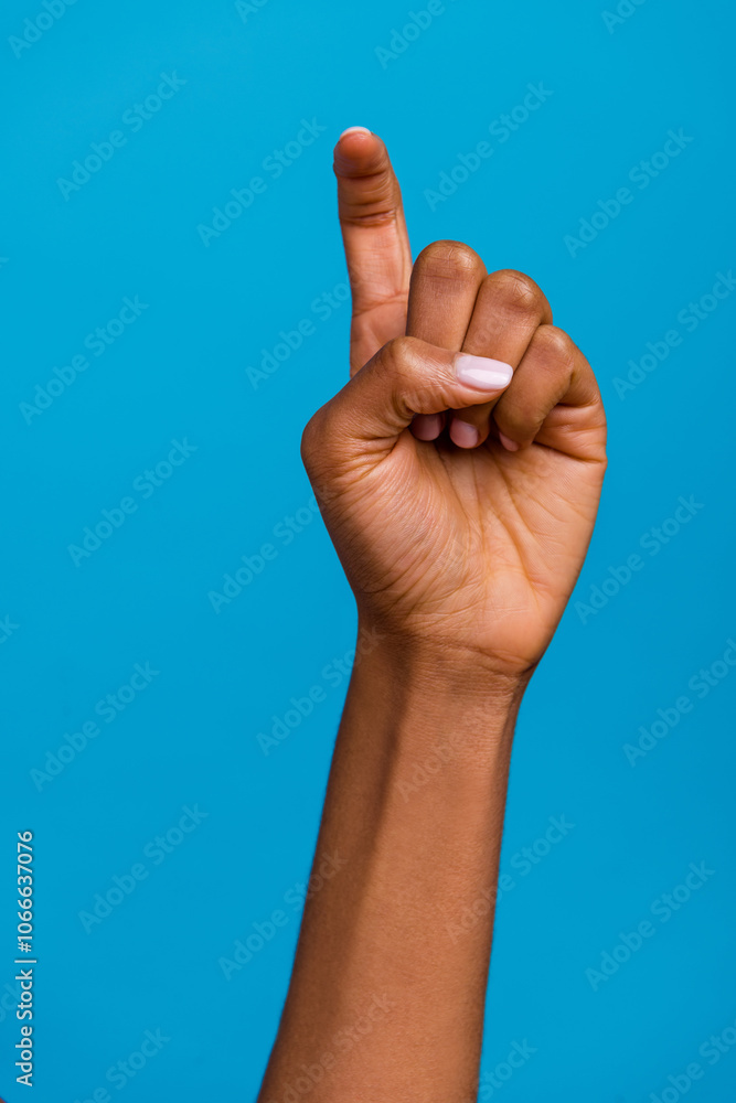 Vertical cropped view of attractive girl hand showing symbol x letter isolated over bright blue color background Vertical cropped view of attractive girl hand showing symbol x letter isolated over bright blue color background