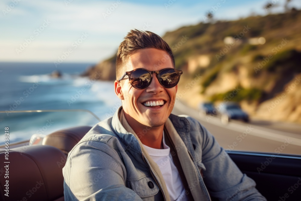 Portrait of a young man driving a convertible car along the coast Portrait of a young man driving a convertible car along the coast