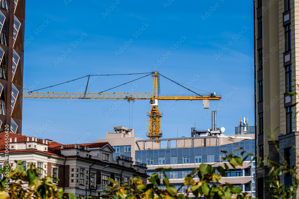 Naklejka premium A tower crane under construction against the sky.