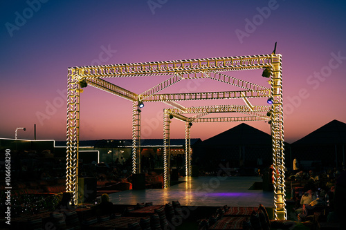 A serene beachfront dining setup in Dubai with flowing white curtains and soft lighting at night, paired with the vibrant cultural charm of a traditional Tanoura dance performance at a desert safari c