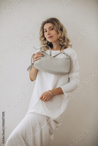 Model, young, beautiful adult blonde woman portrait with handbag in dress, on white background
