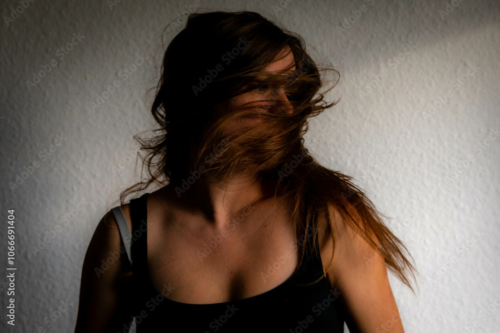 Naklejka premium Female Caucasian shaking her long brown hair and head