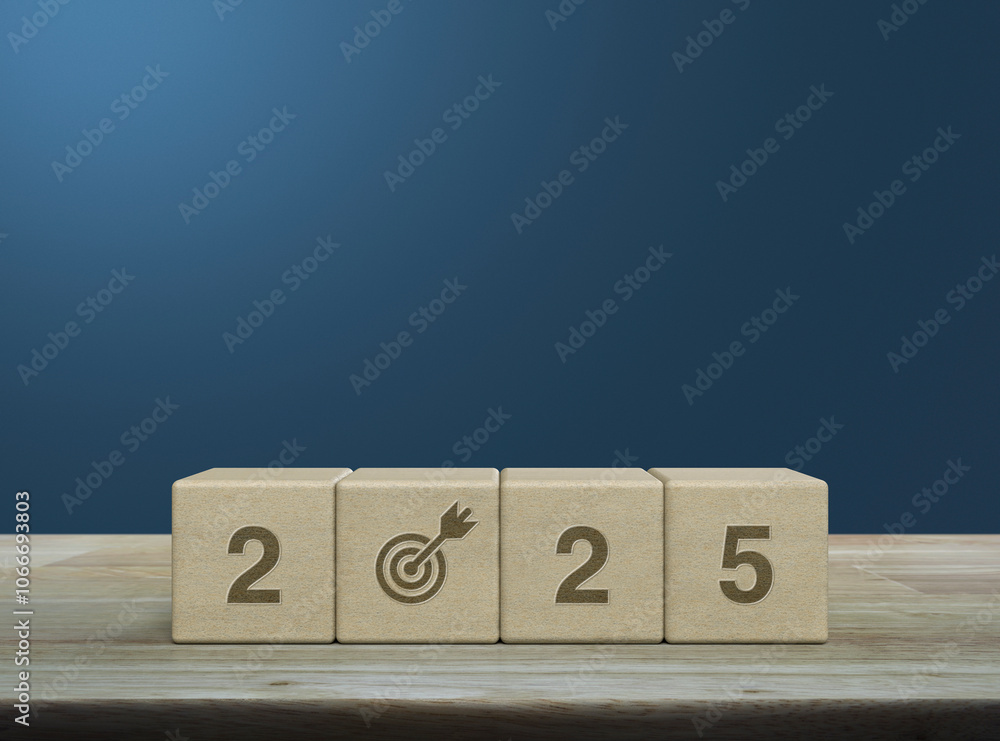 2025 letter with goal icon on wood block cubes on wooden table over light blue wall, Happy new year 2025 success concept 2025 letter with goal icon on wood block cubes on wooden table over light blue wall, Happy new year 2025 success concept