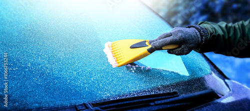 Clearing and remove snow from windshield, Scraping ice. Winter season car window cleaning. Copy space for your text. Panoramatic banner.