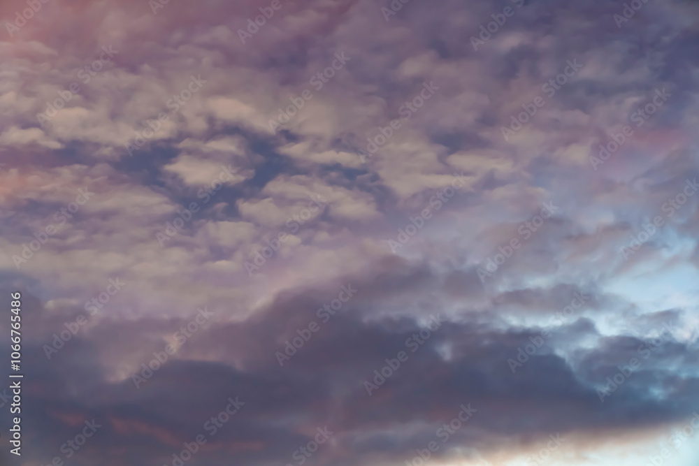Obraz premium Soft pink and purple clouds in a colorful sunset sky. Abstract nature background. Design for wallpaper, poster, banner, greeting card, invitation.