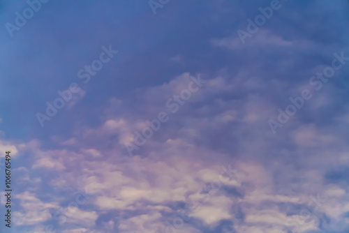 Soft pink and purple clouds in a colorful sunset sky. Abstract nature background. Design for wallpaper, poster, banner, greeting card, invitation.