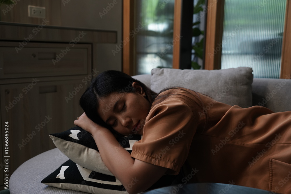 Beautiful Asian woman tired from work feeling lonely sitting and sleeping on the sofa in the company lobby Beautiful Asian woman tired from work feeling lonely sitting and sleeping on the sofa in the company lobby
