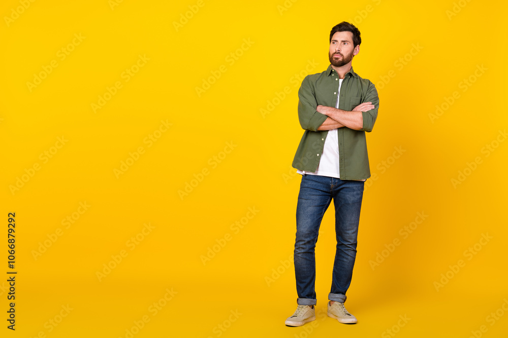 Full size photo of nice young man look empty space wear shirt isolated on yellow color background Full size photo of nice young man look empty space wear shirt isolated on yellow color background