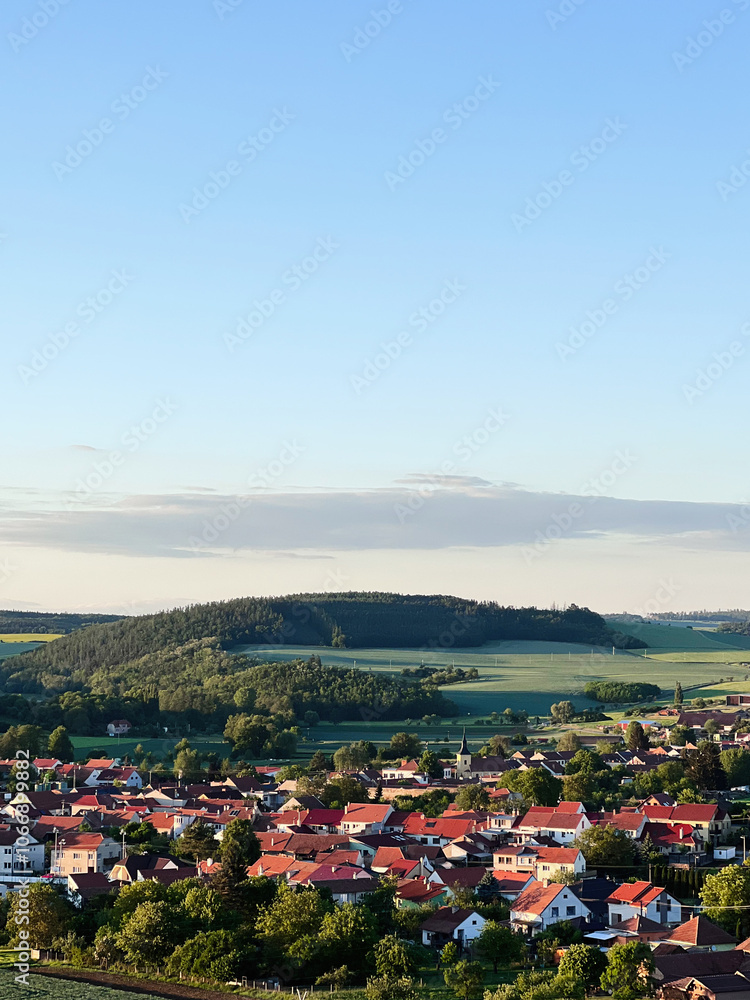 Fototapeta premium Idyllic countryside village with scenic green landscape and blue sky