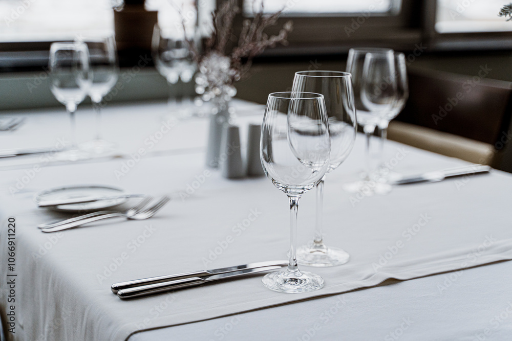 The restaurant features a stylish and contemporary interior complete with elegant table settings and vibrant plants.