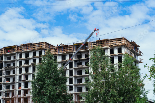 Obraz na płótnie The ongoing construction of a multistory building features cranes and scaffolding raised overhead w salonie