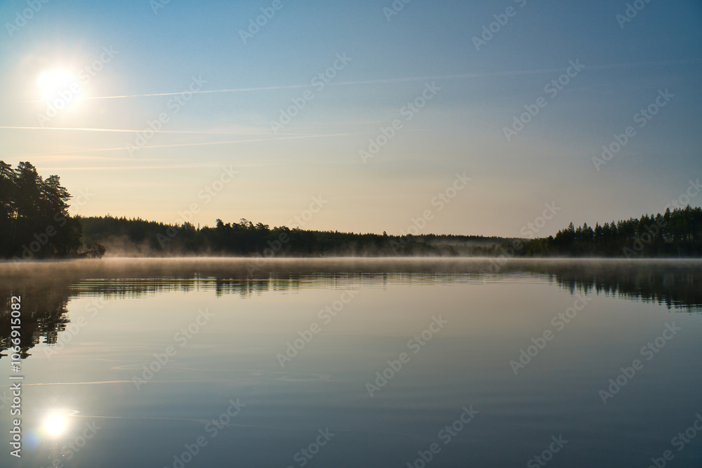 Lake in Sweden, mirror-smooth water with romantic light and trees on the shore Lake in Sweden, mirror-smooth water with romantic light and trees on the shore