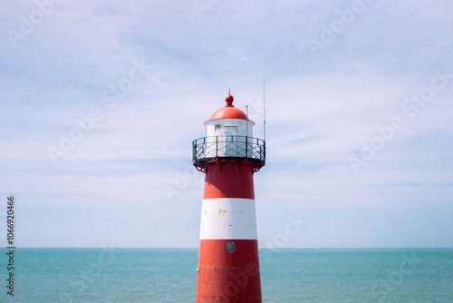 Red White Striped Lighthouse at the Seaside in Netherlands Sea Lake Water Blue