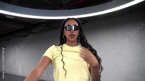 Young woman with braids puts on futuristic sunglasses