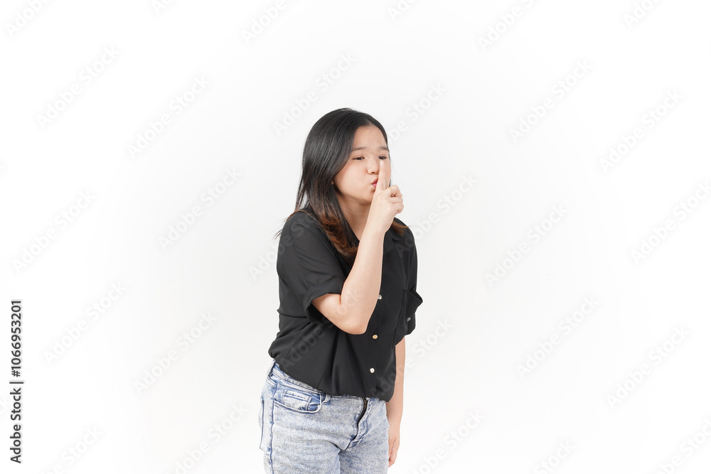 beautiful Asian woman holds a finger to her lips in a 'shh' gesture, signaling silence against a white background beautiful Asian woman holds a finger to her lips in a 'shh' gesture, signaling silence against a white background