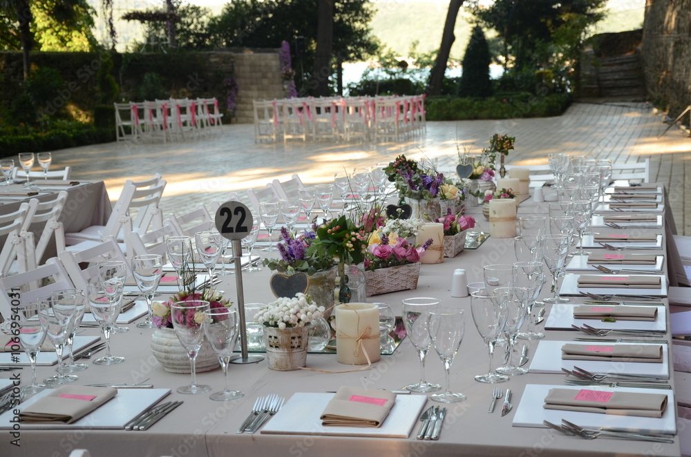 Beautiful Wedding Decor: Tables with Lush Floral Arrangements and Candles Outdoors at Evening