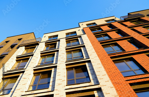 Modern facade building. Facade of high rise urban Modern house. balcony and Windows . Architecture building exterior, house block. High Rise house. Residential development in UK. City built. Blue sky.