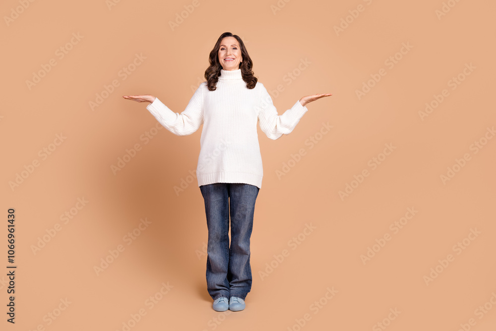 Photo of lovely adorable woman wear stylish clothes presenting empty space isolated on beige color background Photo of lovely adorable woman wear stylish clothes presenting empty space isolated on beige color background