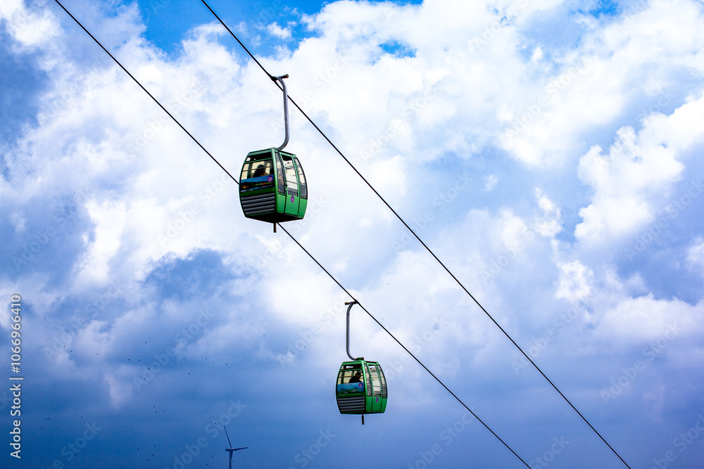 two ski lifts are suspended in the air one of which is a cable car two ski lifts are suspended in the air one of which is a cable car