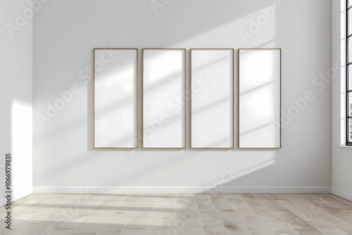 A bright, minimalist room featuring four empty, framed canvases arranged on a white wall, illuminated by soft natural light. photo