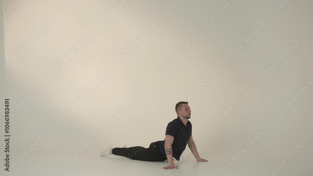 A Man Engaged in Practicing a Yoga Pose Set Against a Minimalist Background Environment A Man Engaged in Practicing a Yoga Pose Set Against a Minimalist Background Environment