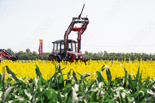 Red tractor in a field and dramatic clouds photo