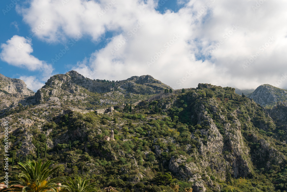 Fototapeta premium Walls of the Kotor Fortress with mountains and blue sky, Montenegro