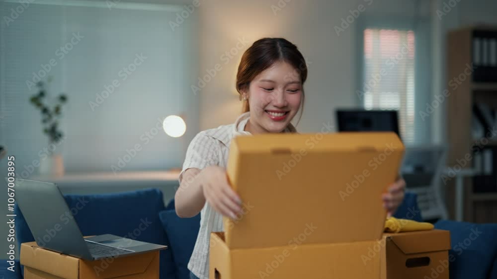 Young asian woman packing clothes into a cardboard box for shipping, showcasing the process of running an online business Young asian woman packing clothes into a cardboard box for shipping, showcasing the process of running an online business