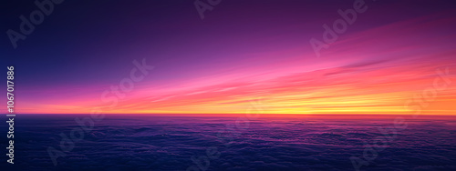 A breathtaking sunset over the clouds, featuring vibrant shades of purple, pink, and orange, evoking a serene and tranquil atmosphere.